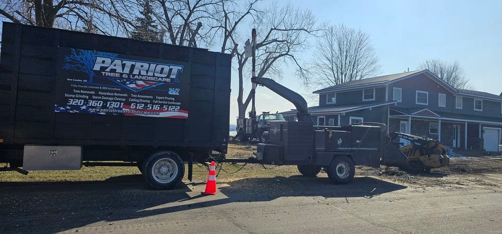 Patriot Tree and Landscape truck near a house, with tree removal equipment visible.